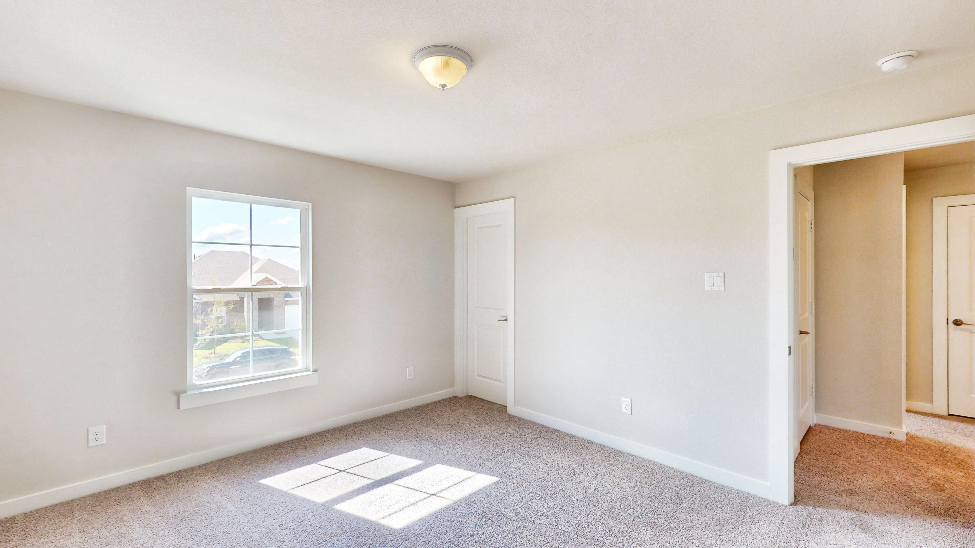 A room with a window and a carpet.