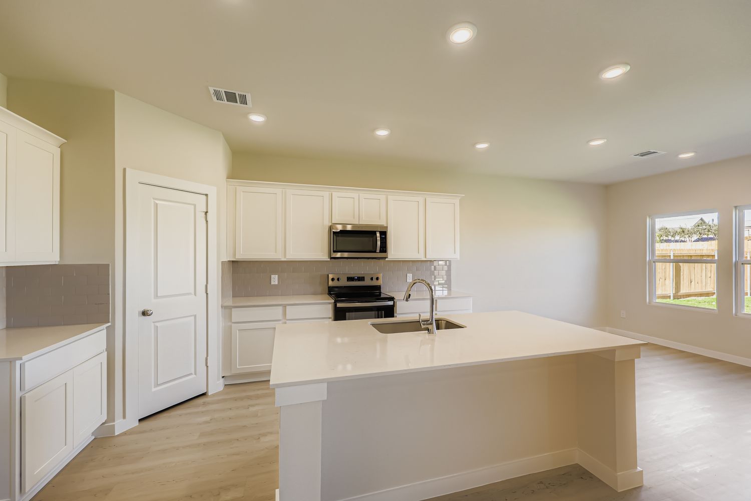 A kitchen with white cabinets.