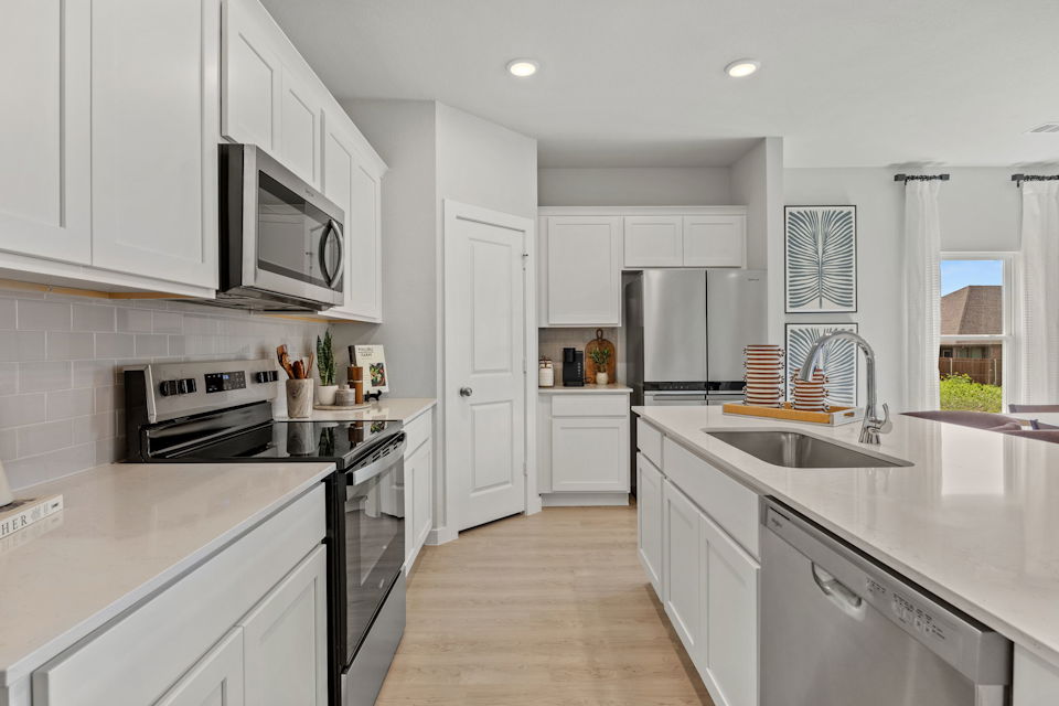 A kitchen with white cabinets.