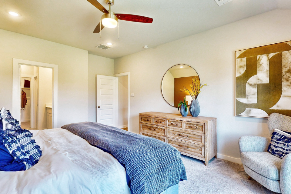 A bedroom with a bed and a mirror.