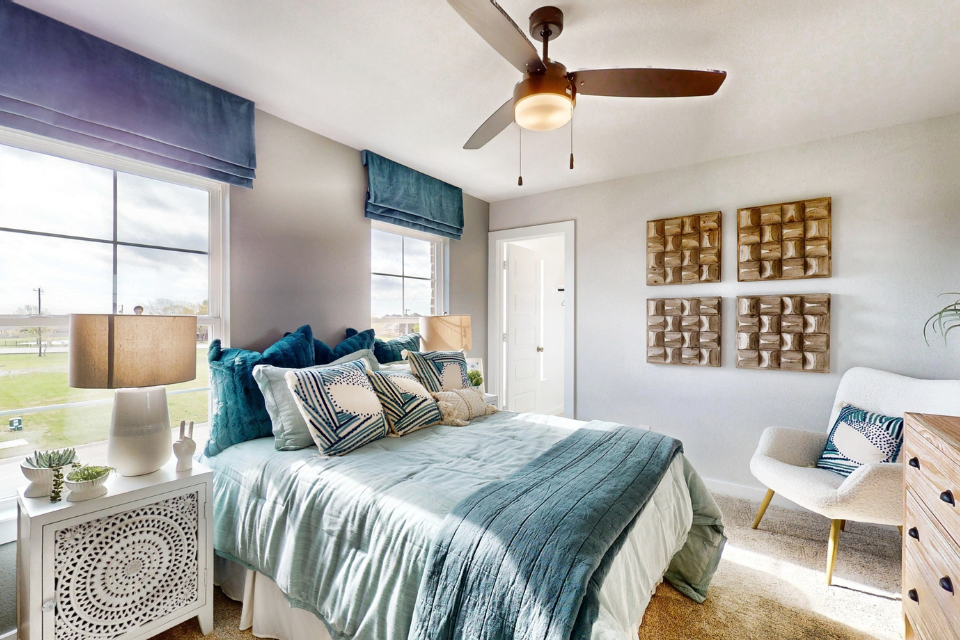 A bedroom with a bed and a fan.