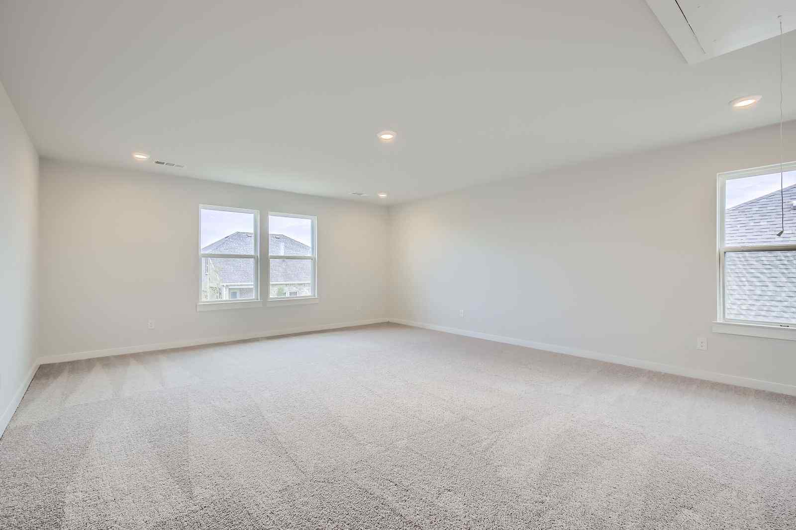 A room with a carpet and windows.