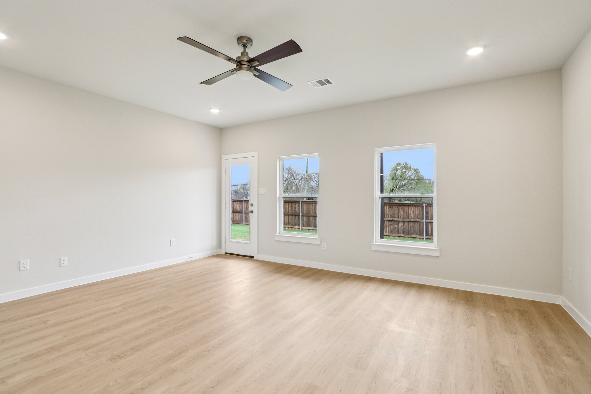 A room with a wood floor and a ceiling fan.