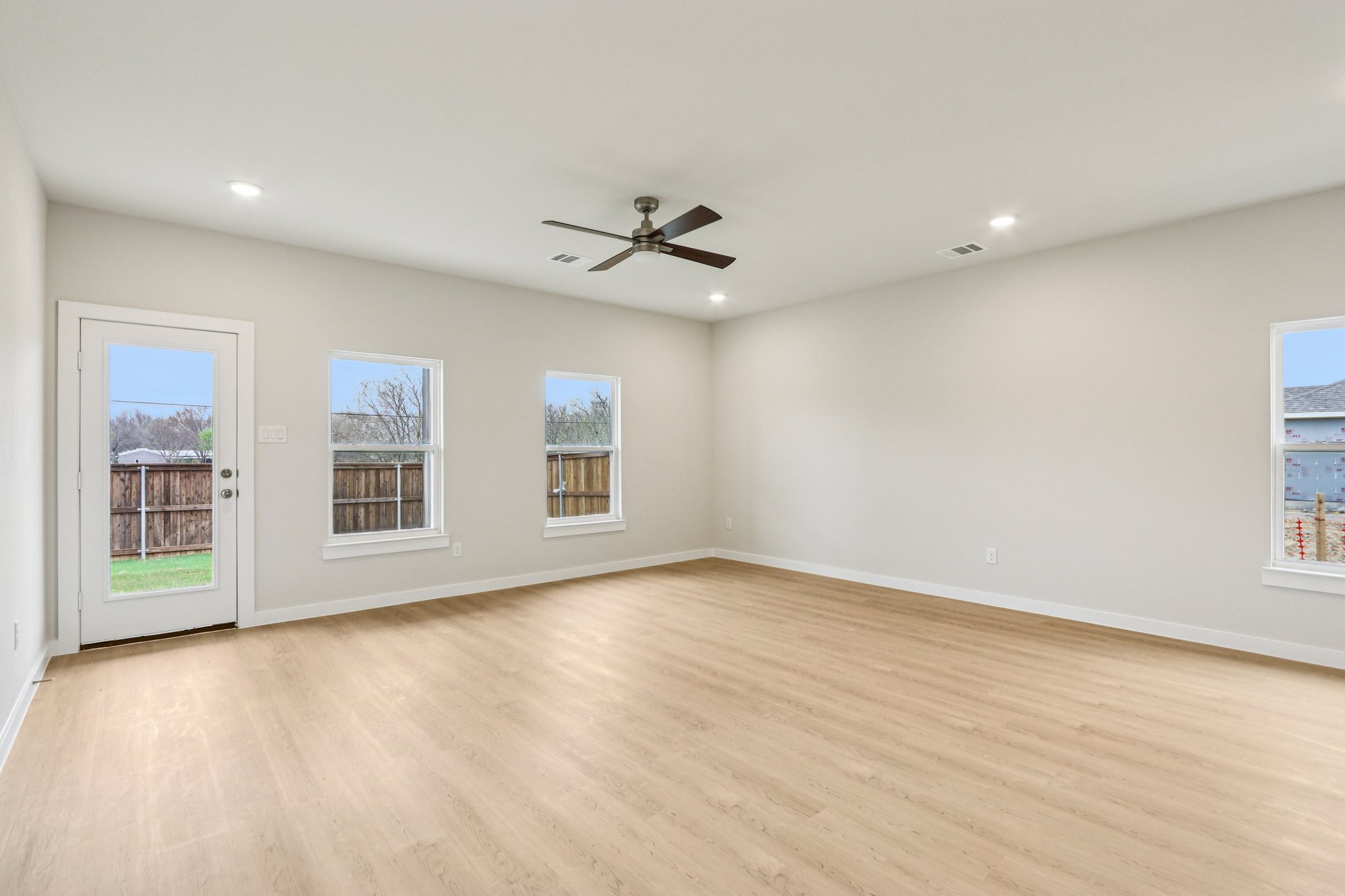 A room with a wood floor and a ceiling fan.