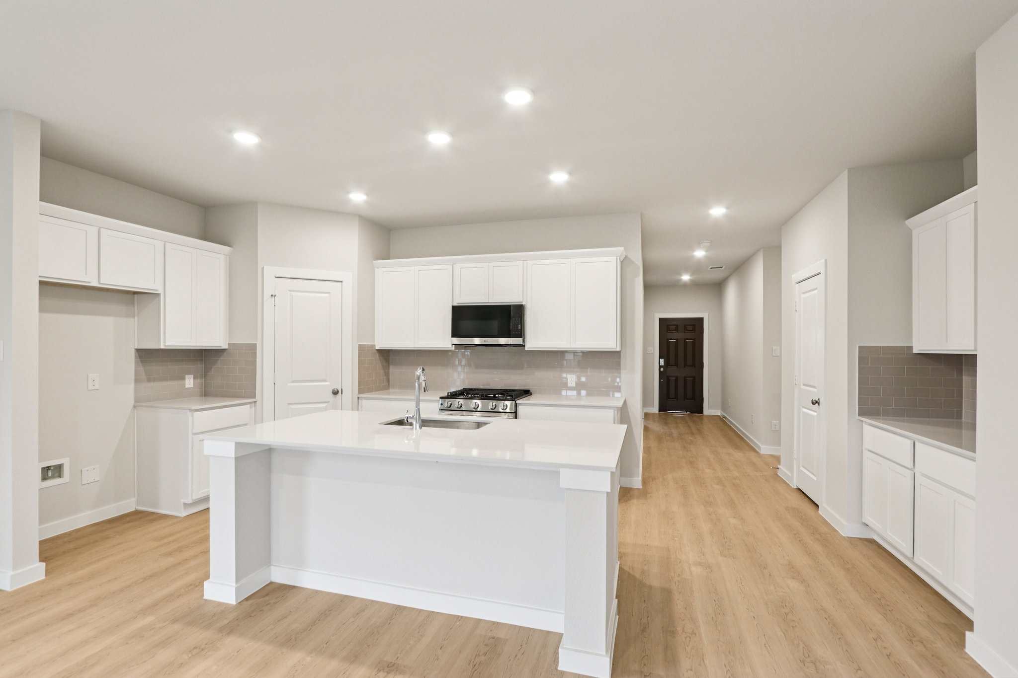 A kitchen with white cabinets.