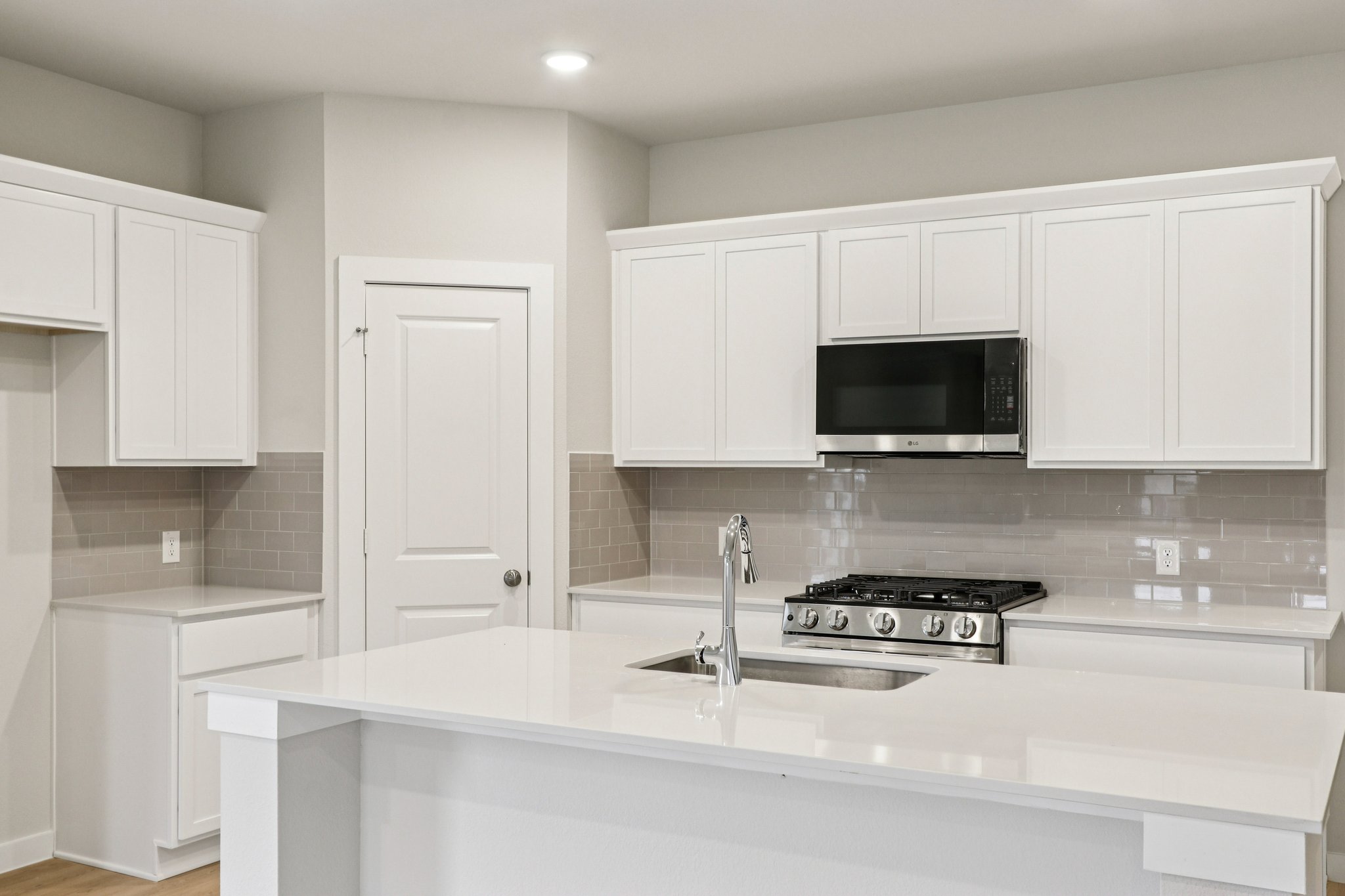 A kitchen with white cabinets.