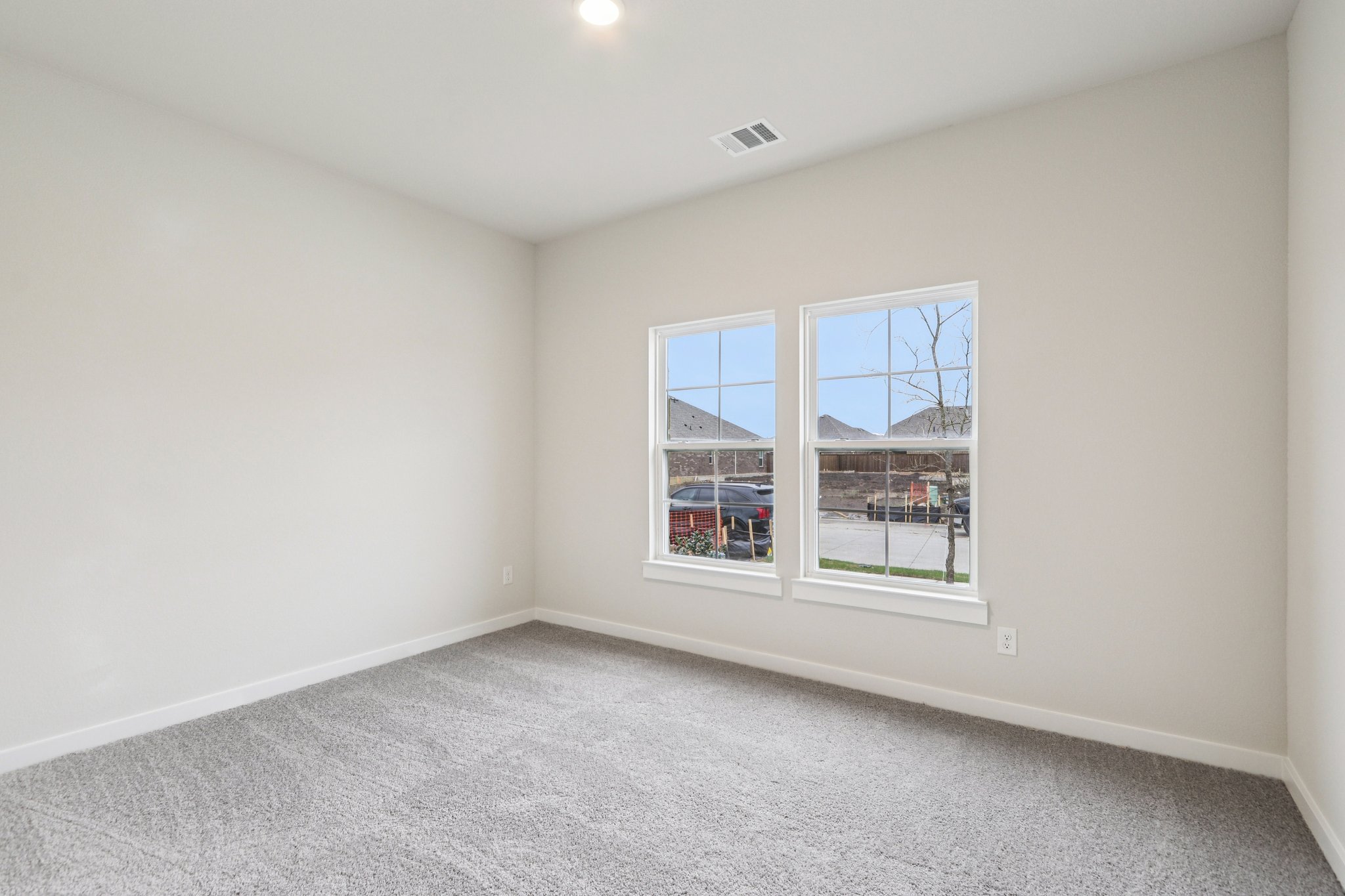 A room with a window and a carpet.