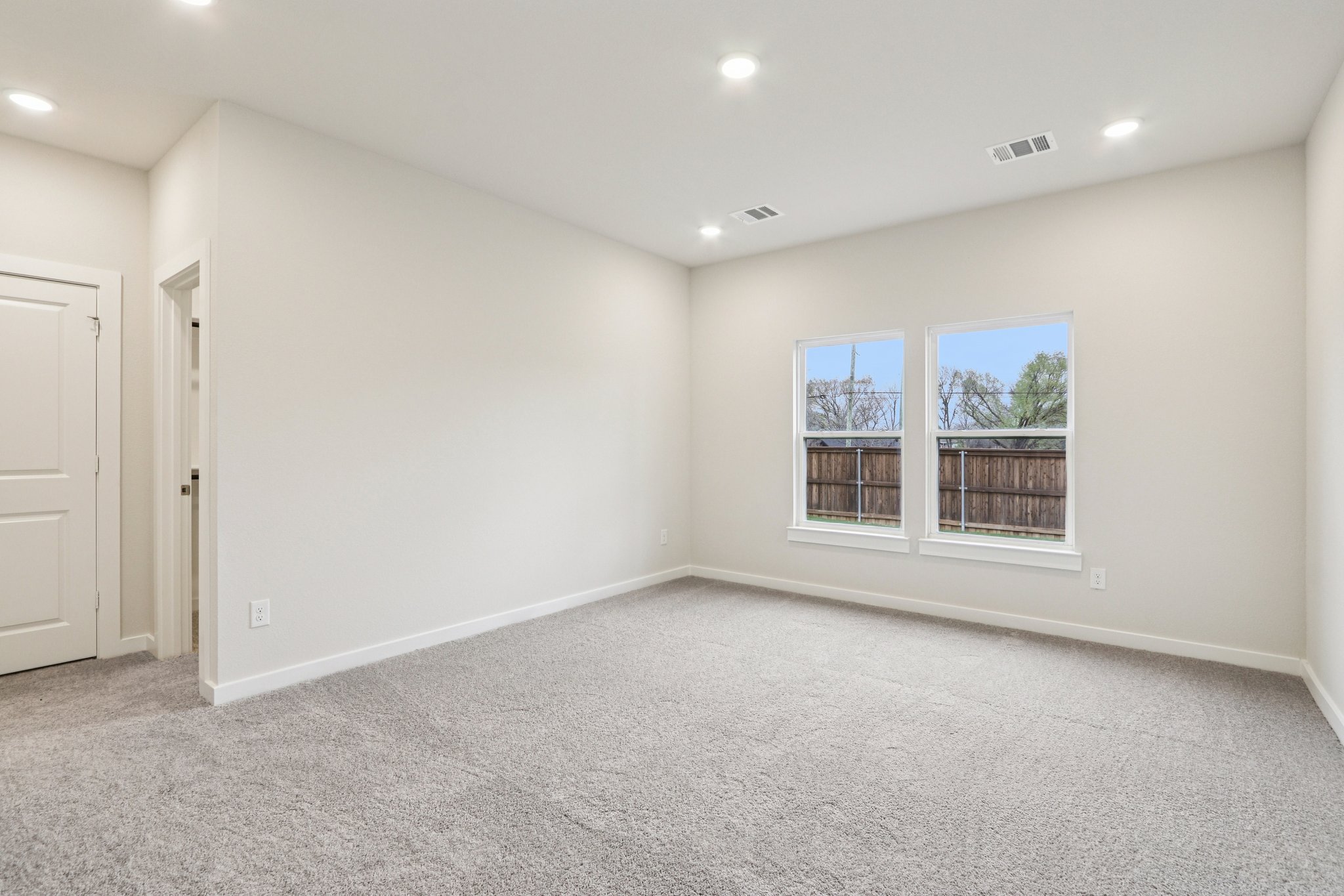 A room with a window and a carpet.