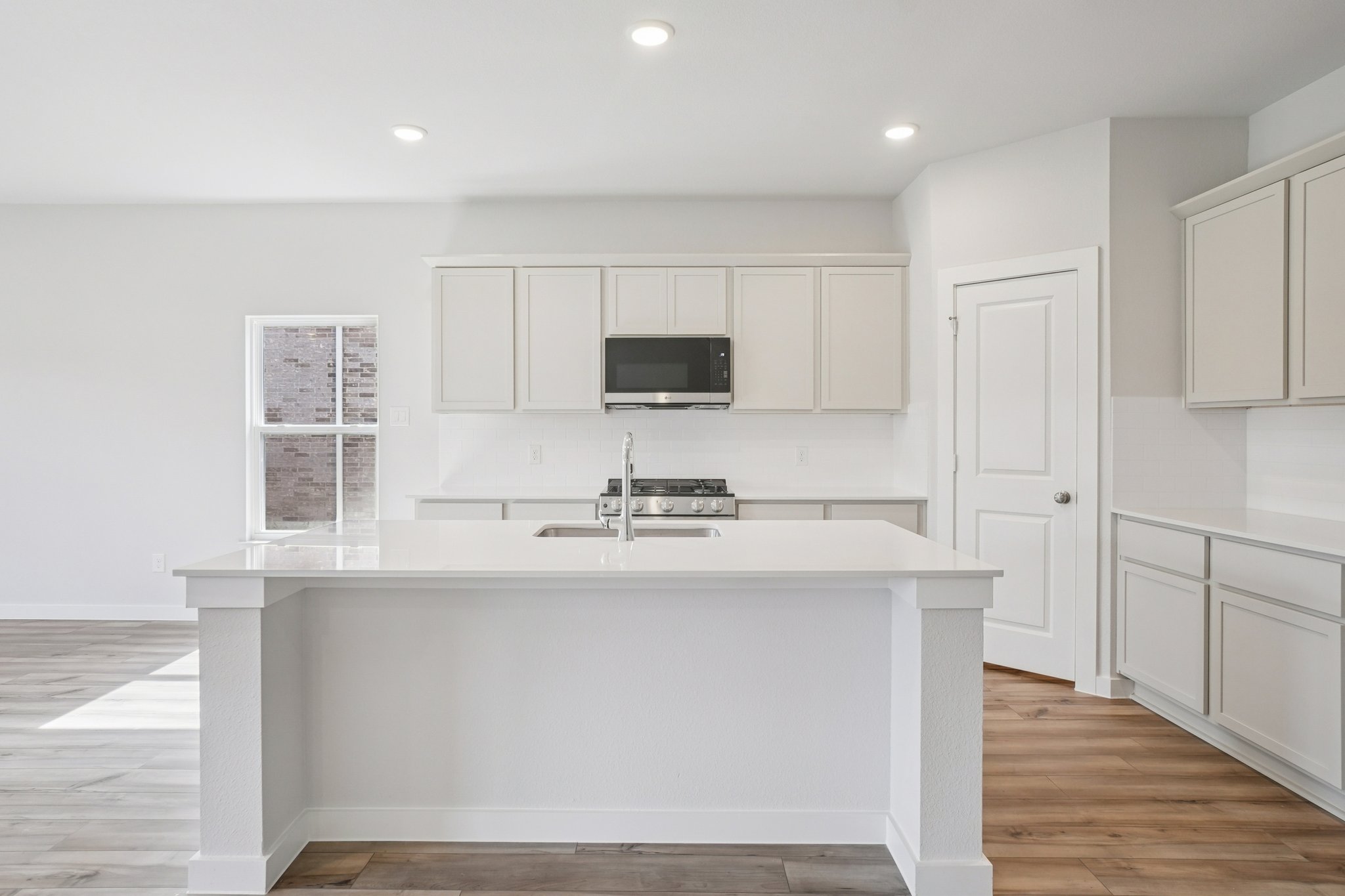 A kitchen with white cabinets.