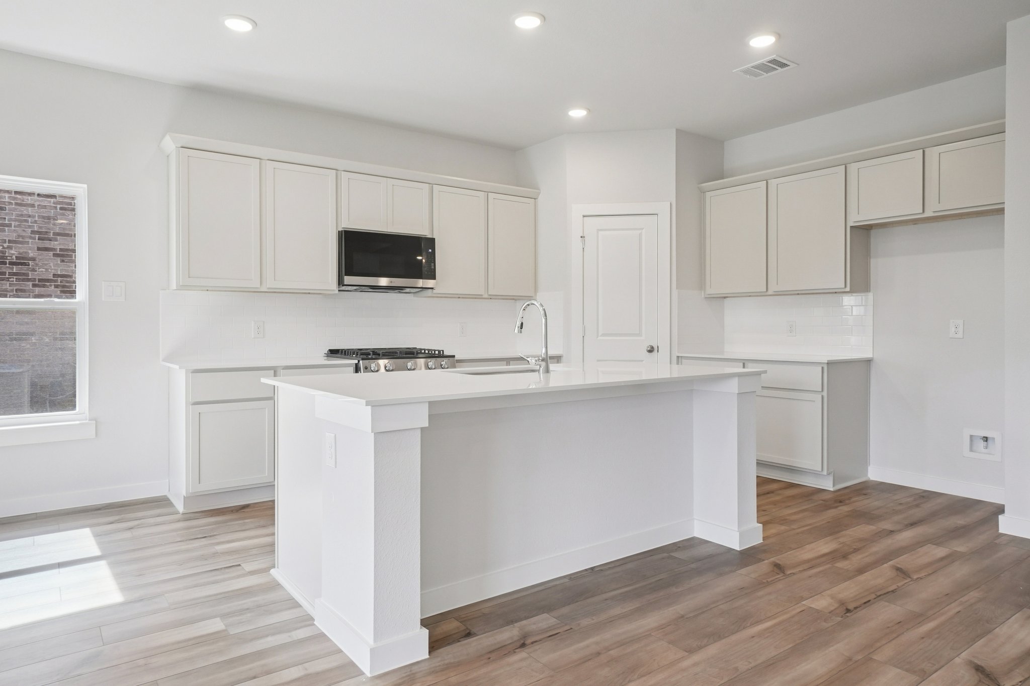 A kitchen with white cabinets.