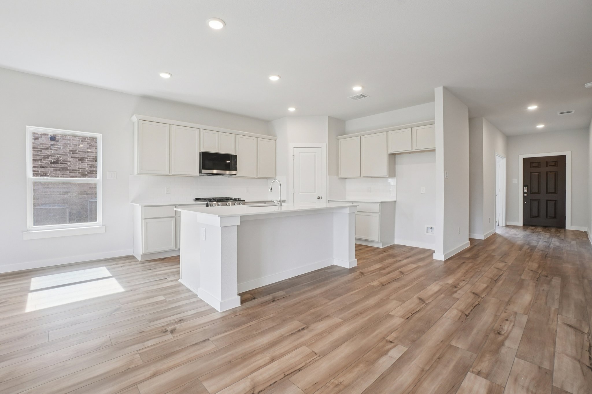 A kitchen with white cabinets.