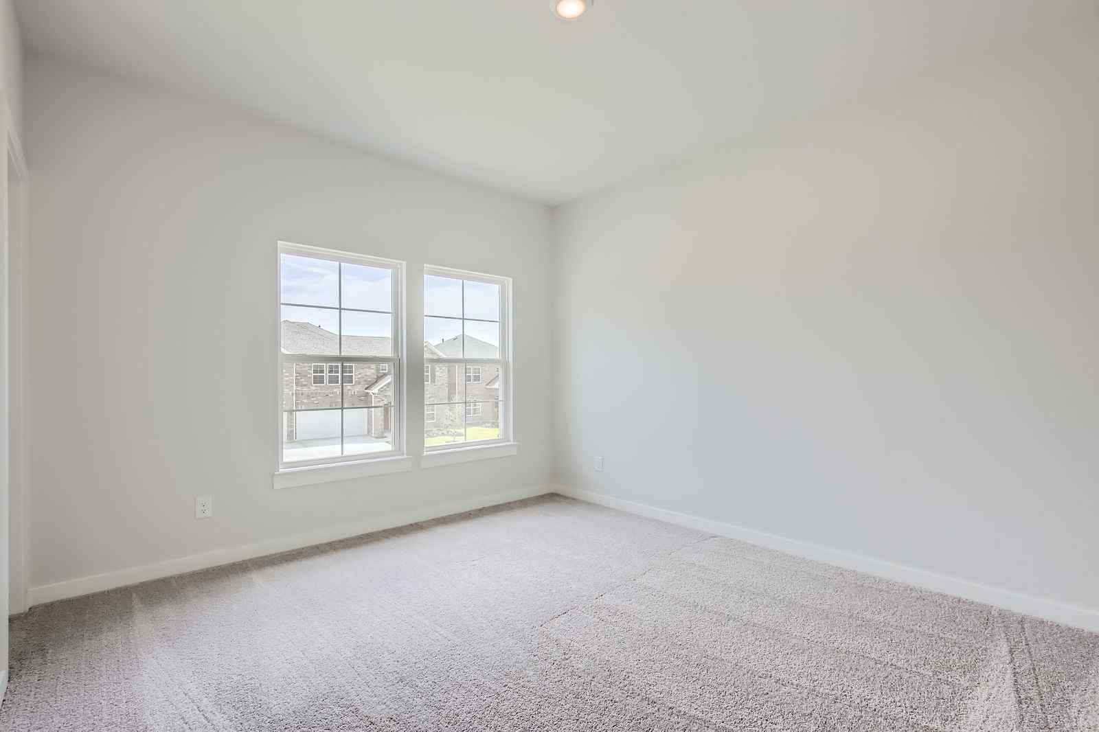 A room with a window and a white wall.