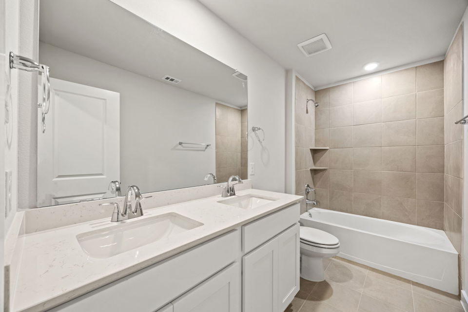 A bathroom with a tub sink and toilet.