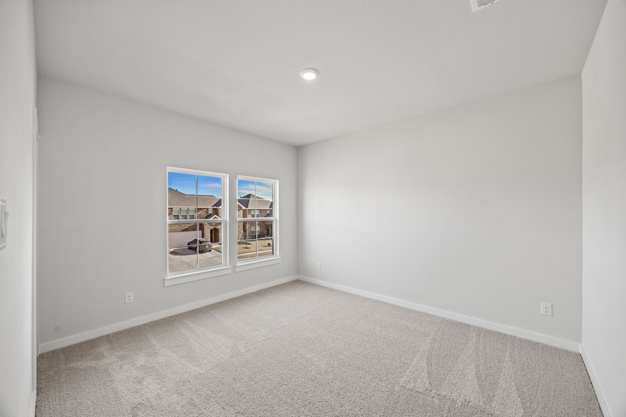 A room with a window and a carpet.