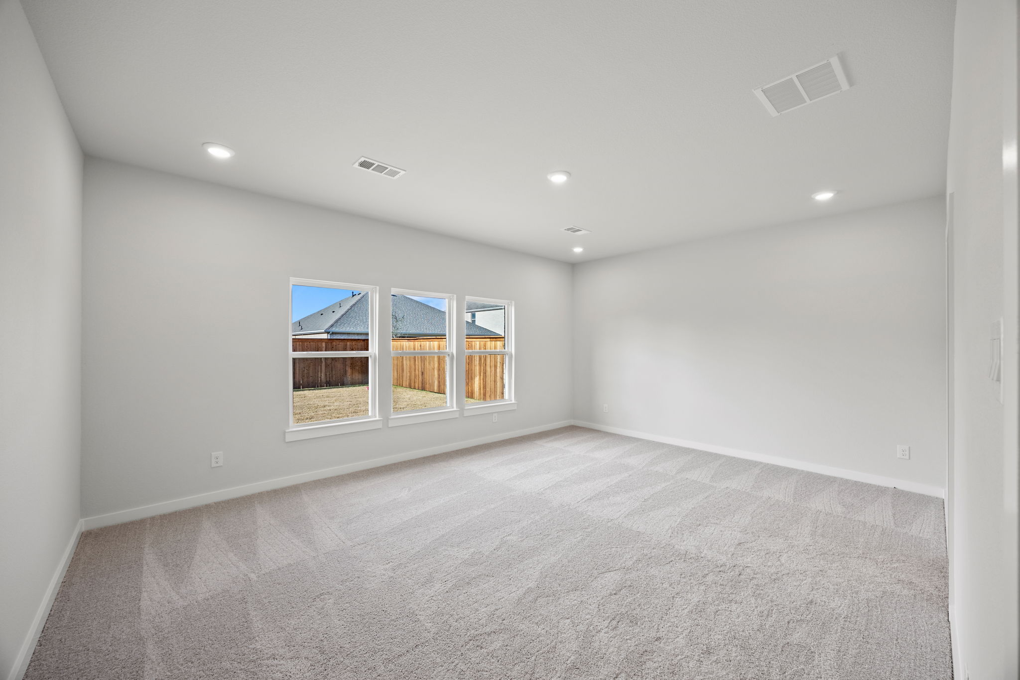 A room with a window and a rug.