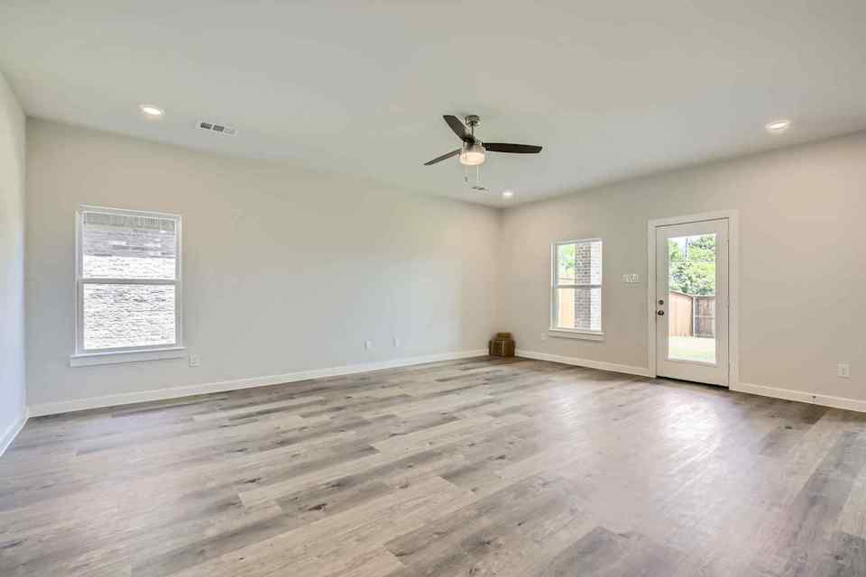 A room with a wood floor and a ceiling fan.