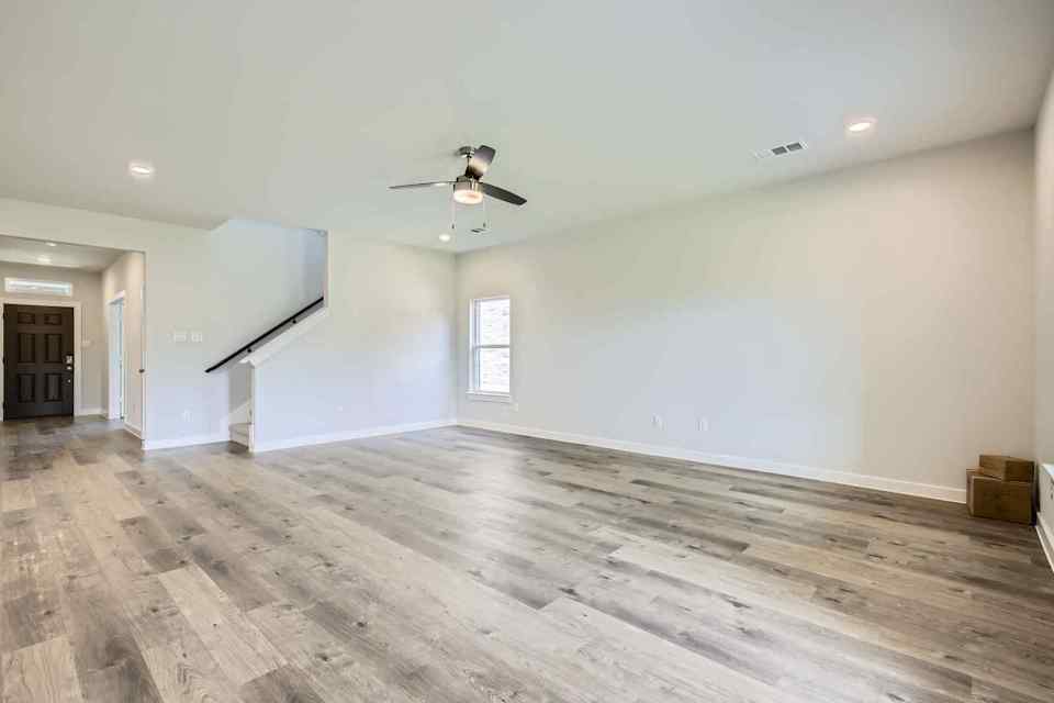 A room with a wood floor and a ceiling fan.