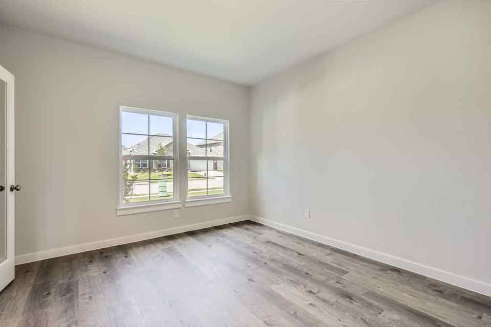 A room with a wood floor and a window.