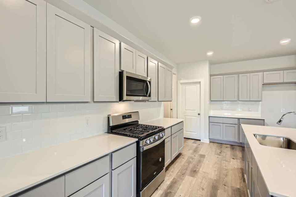 A kitchen with white cabinets.
