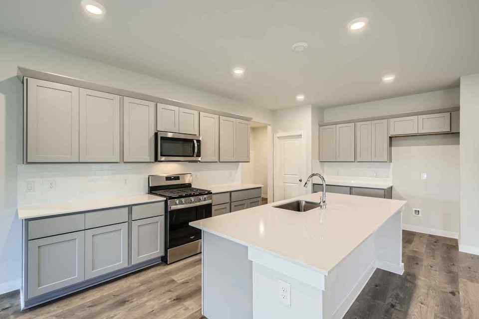 A kitchen with white cabinets.