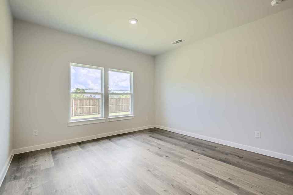 A room with a wood floor and a window.