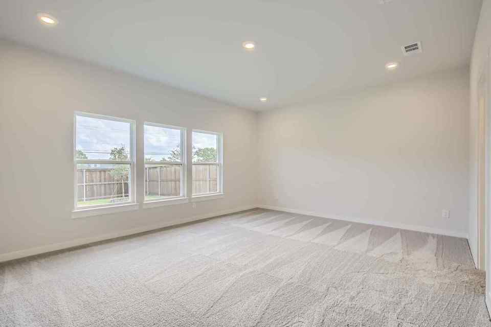 A room with a carpet and windows.