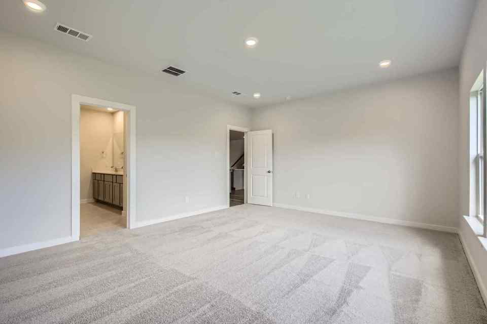 A room with a carpet and a door.