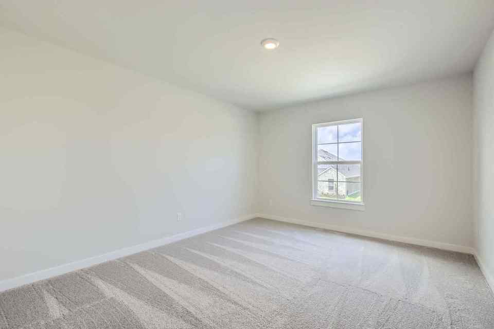 A room with a window and a carpet.