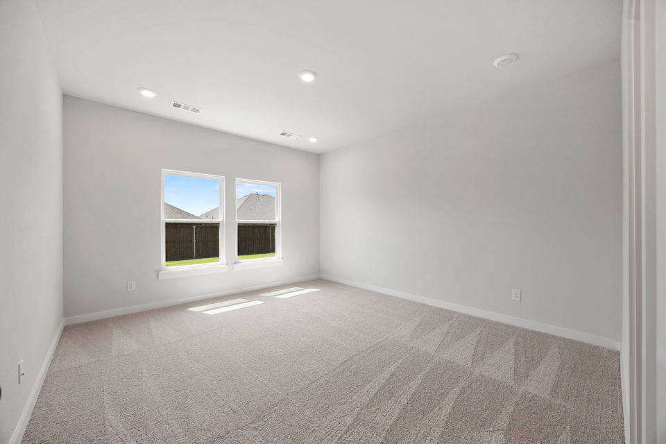 A room with a carpet and windows.