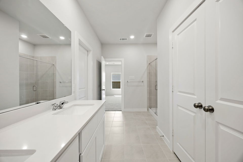 A bathroom with white cabinets.