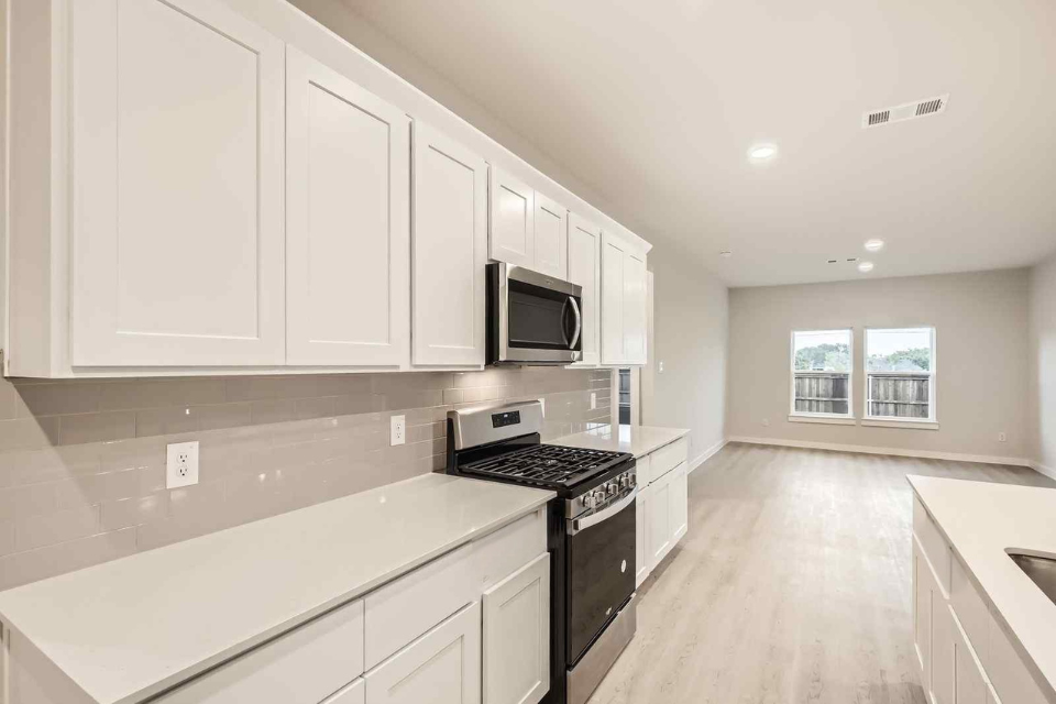 A kitchen with white cabinets.