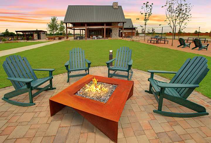 A fire pit with chairs around it.