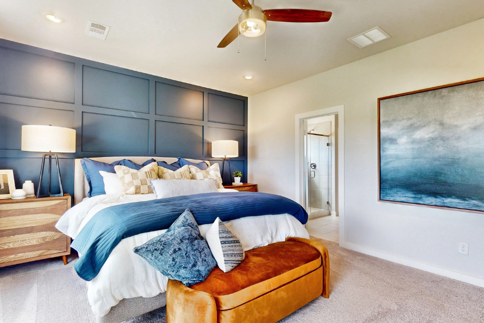 A bedroom with a large bed and a fan.