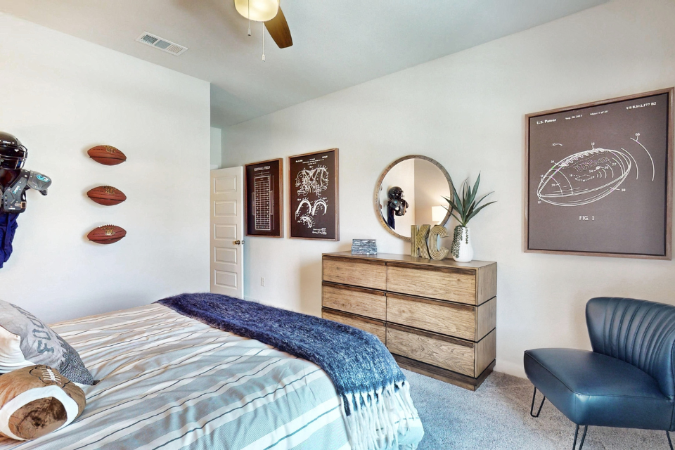 A bedroom with a bed and a chair.