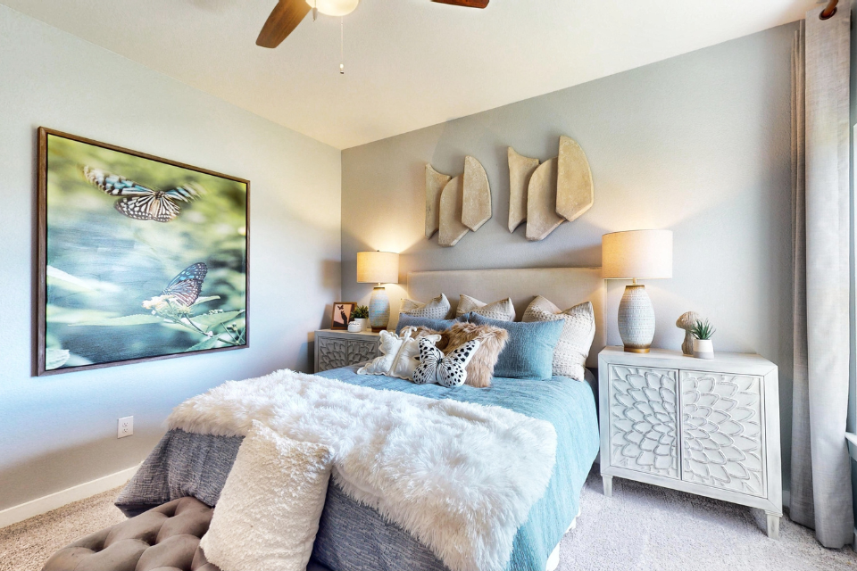 A bedroom with a large painting on the wall.