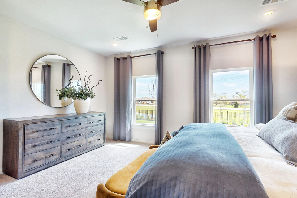 A bedroom with a large window.