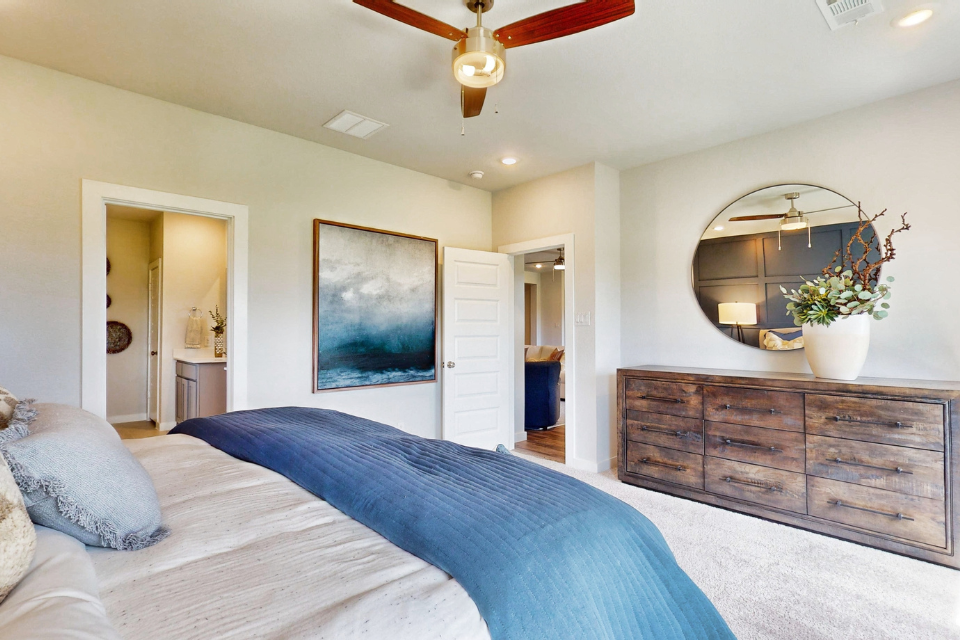 A bedroom with a large mirror.