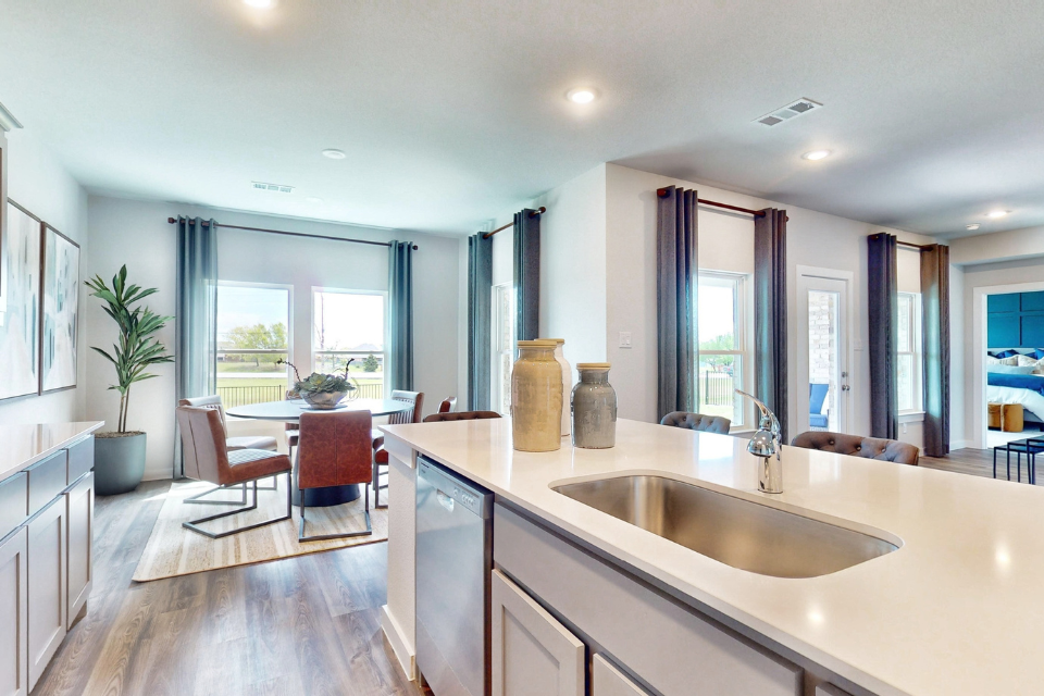 A kitchen with a sink and a dining table.