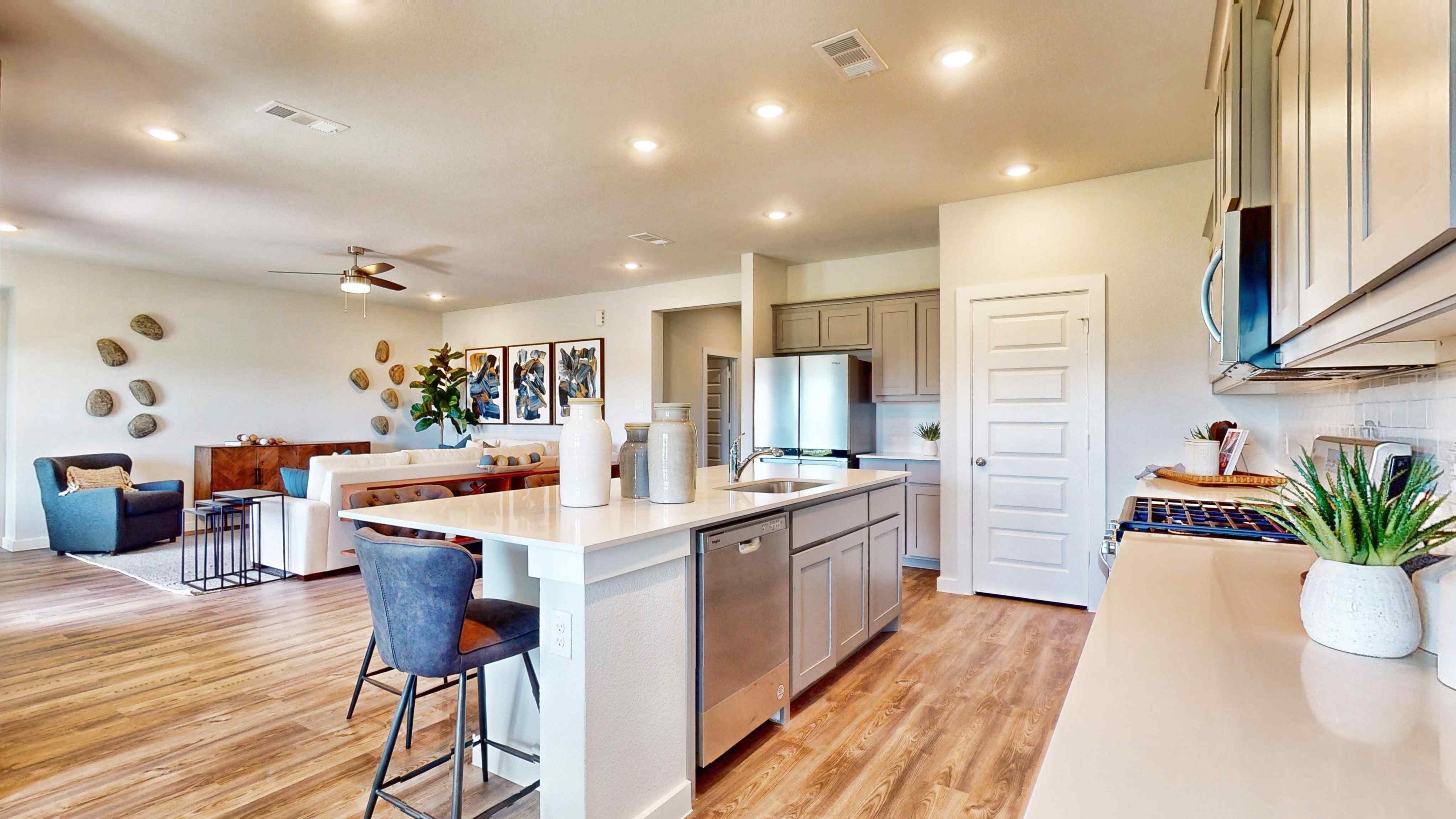 A kitchen with a bar and chairs.