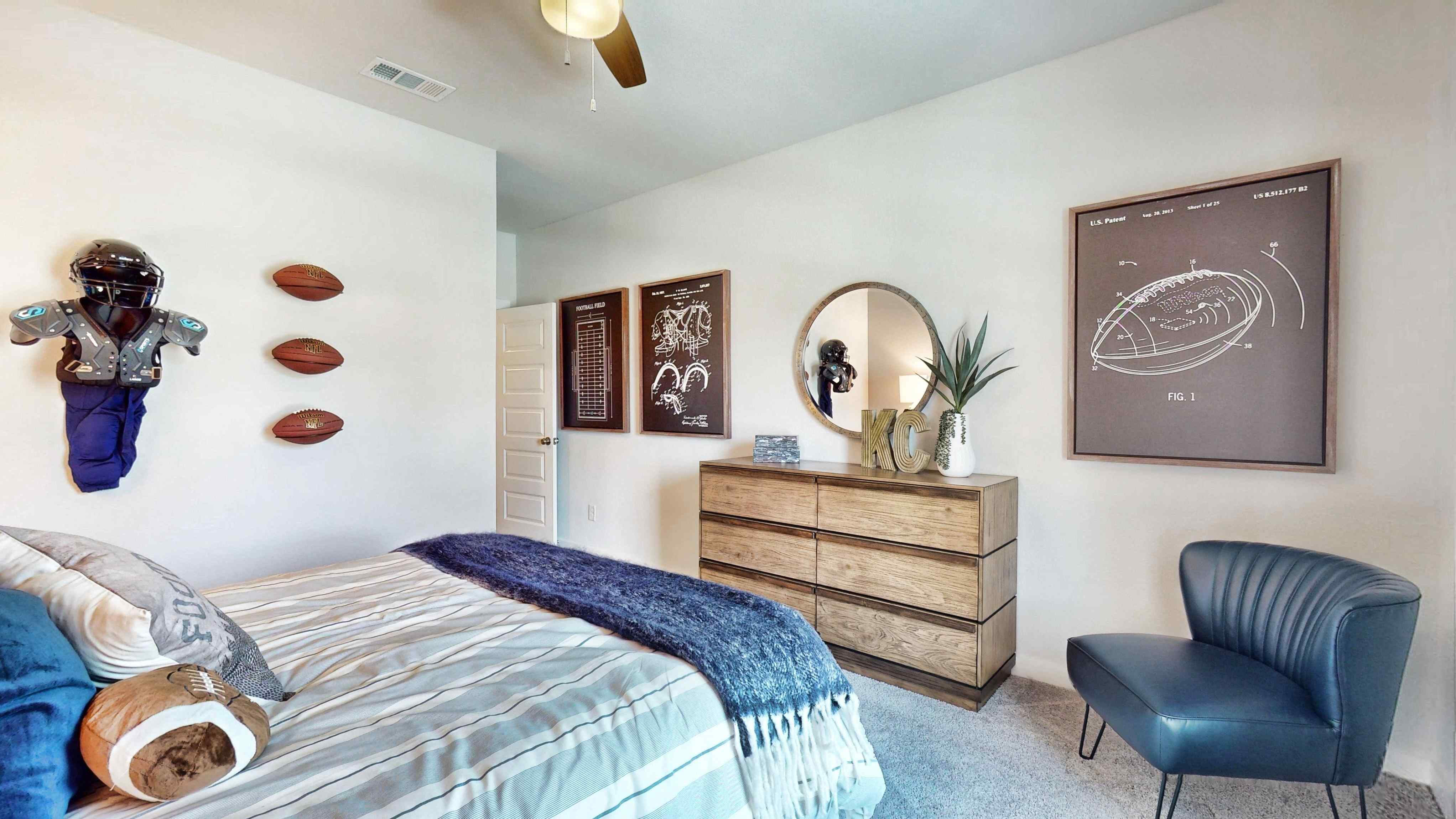 A bedroom with a bed and a chair.