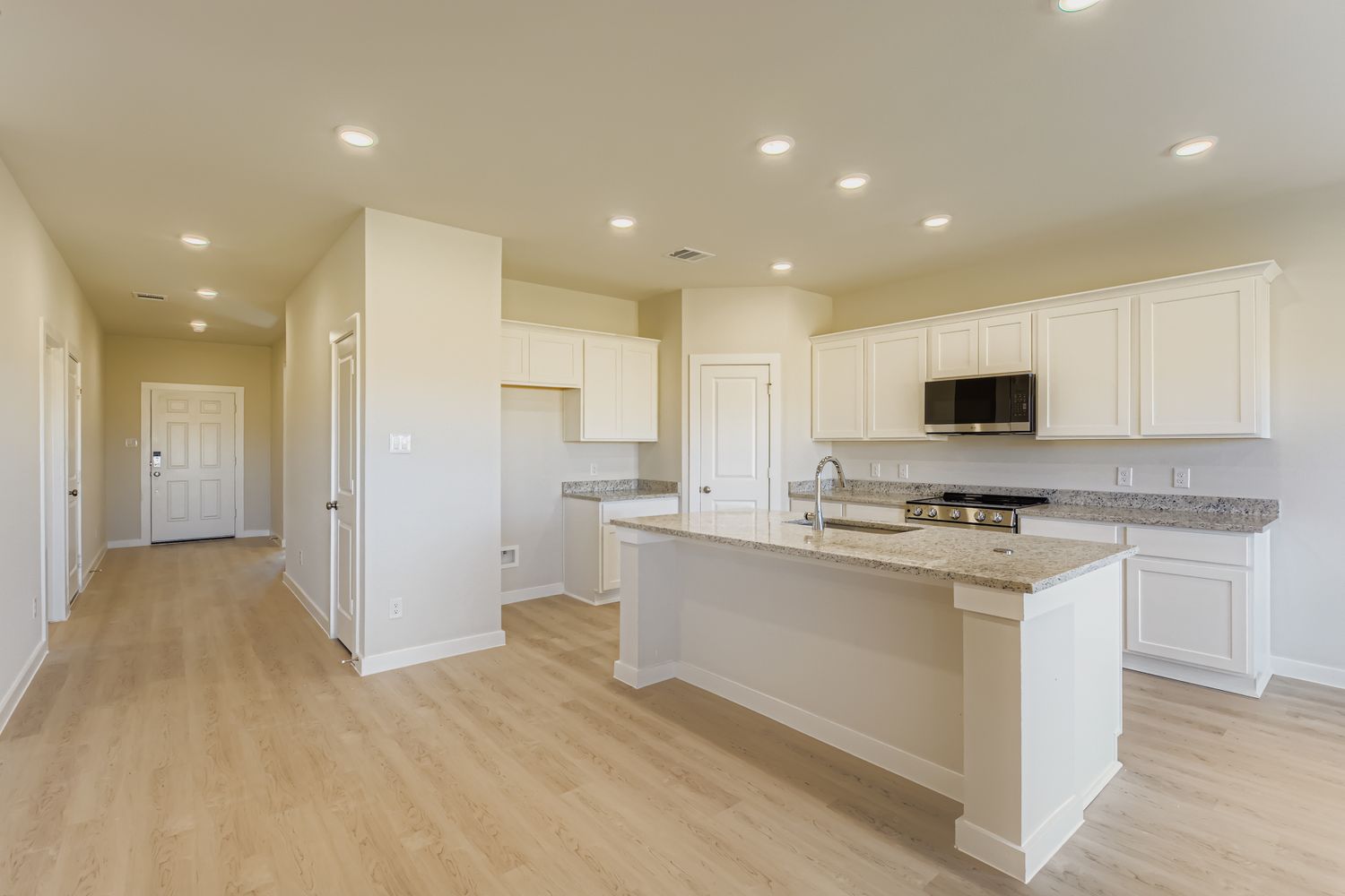 A kitchen with white cabinets.