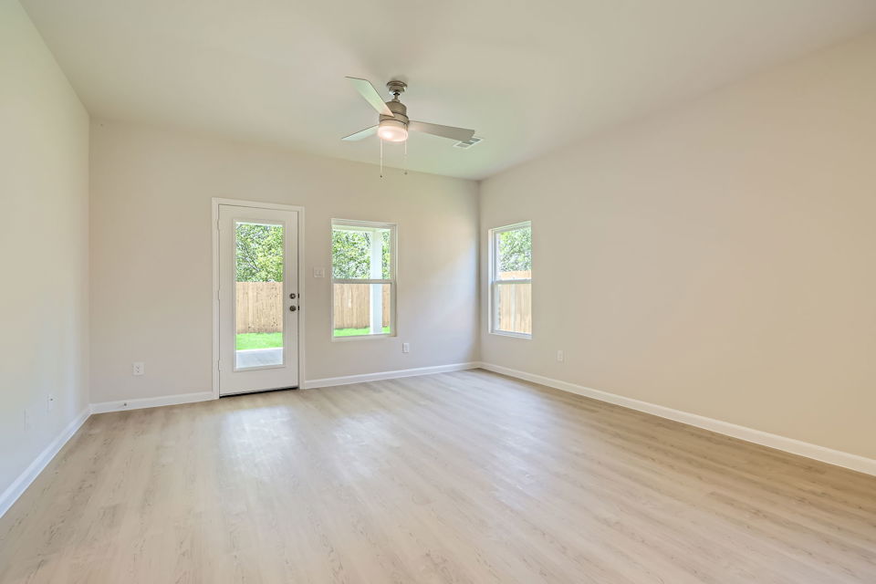 A room with a wood floor and a ceiling fan.