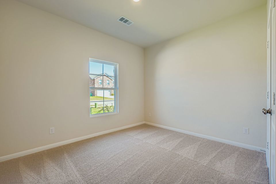 A room with a window and a carpet.