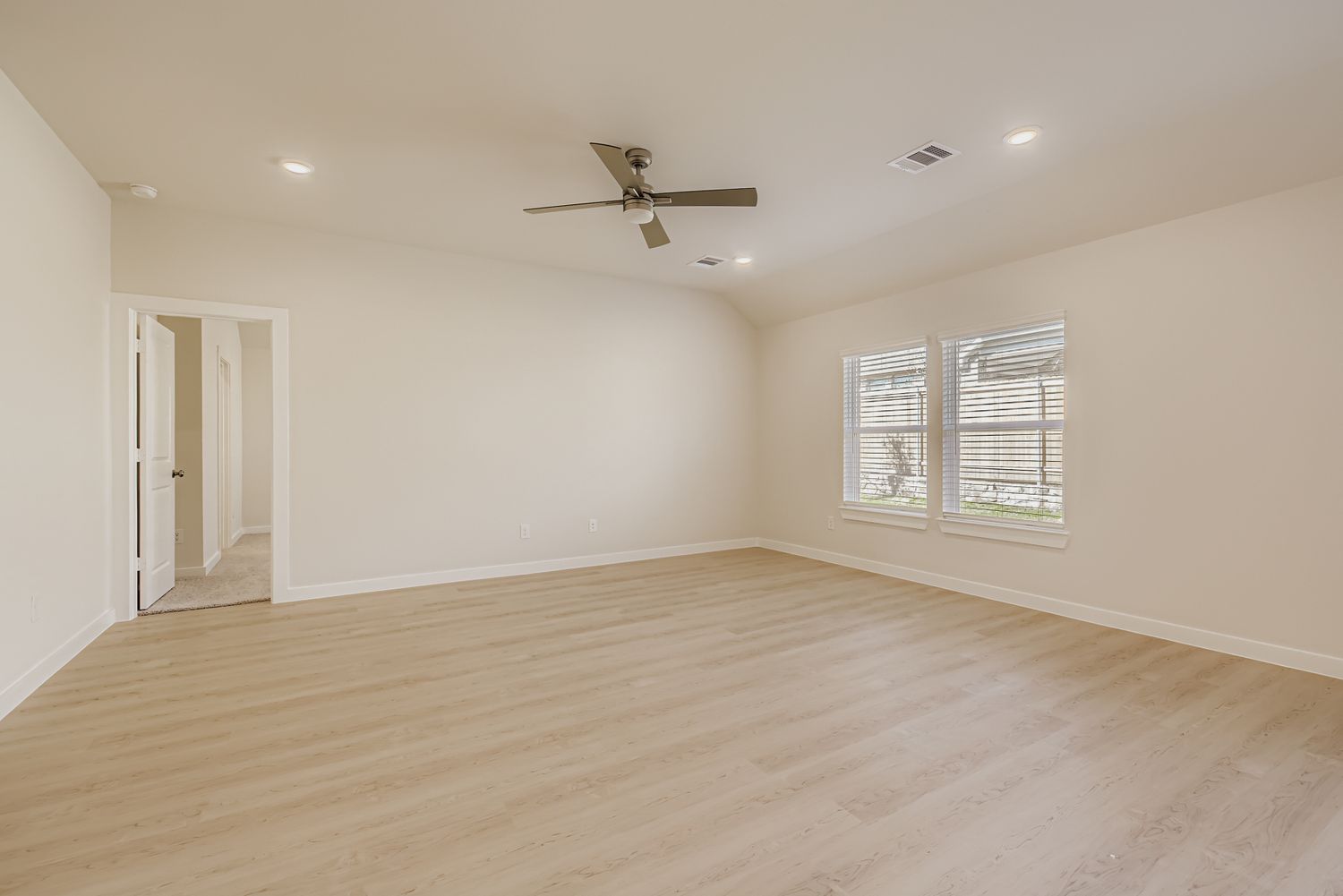 A room with a wood floor and a ceiling fan.