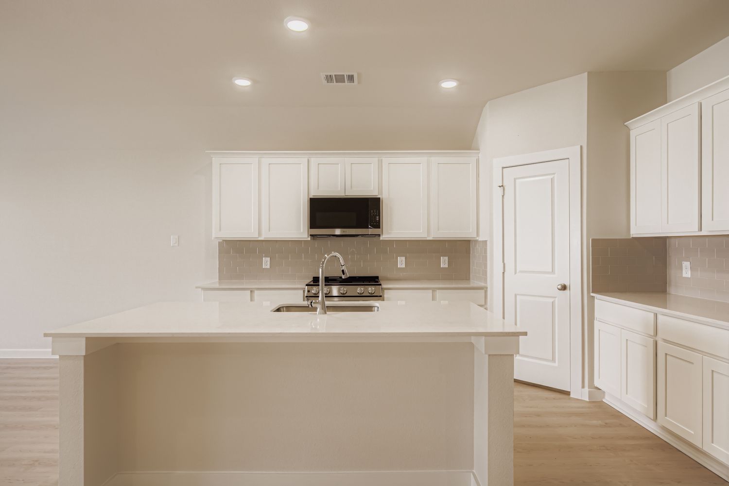 A kitchen with white cabinets.