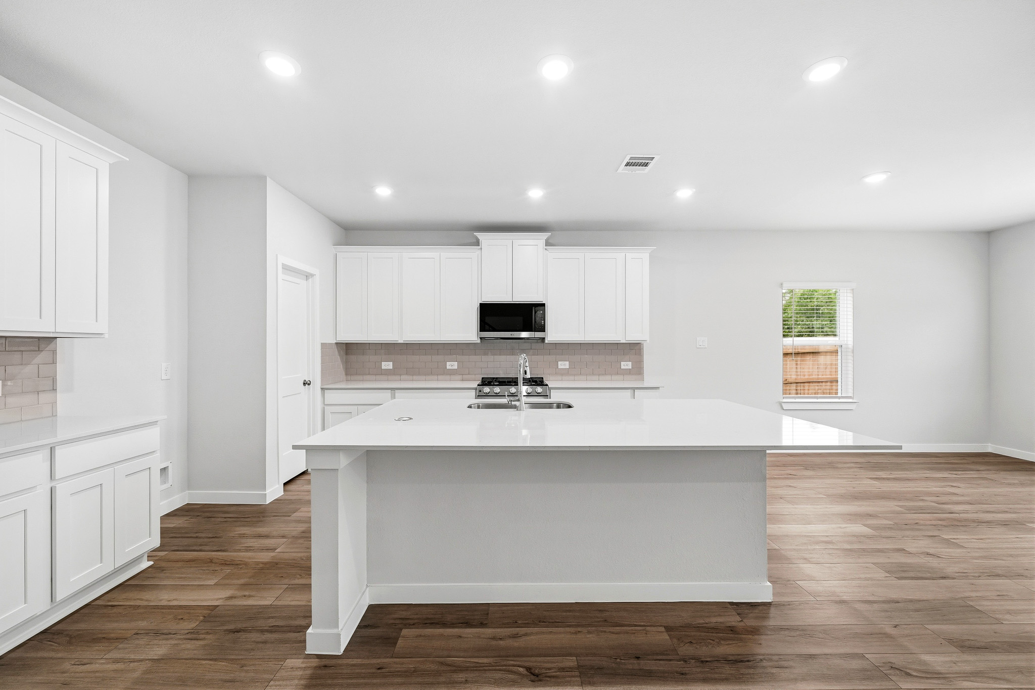 A kitchen with white cabinets.