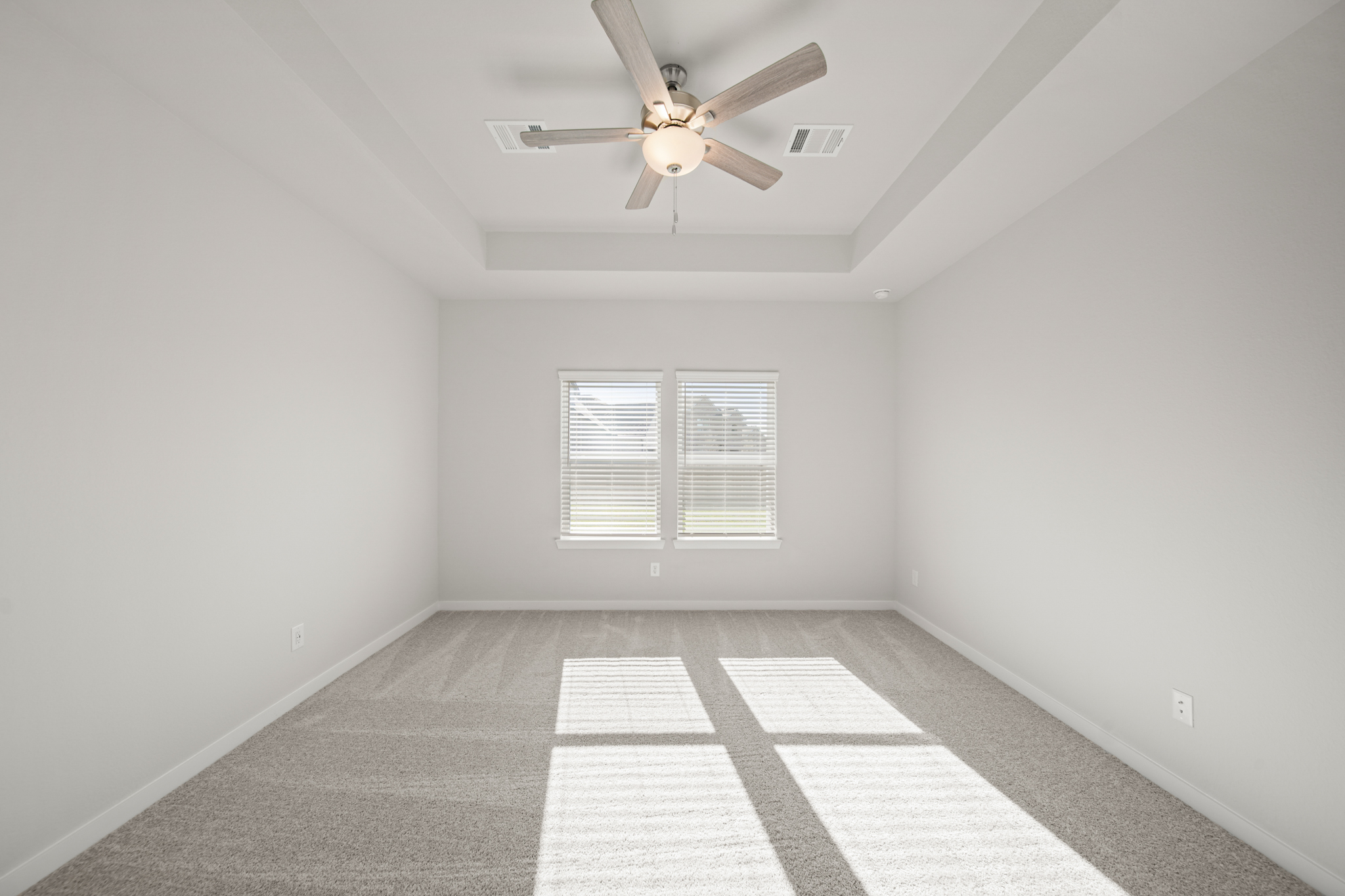 A room with a ceiling fan and a tile floor.