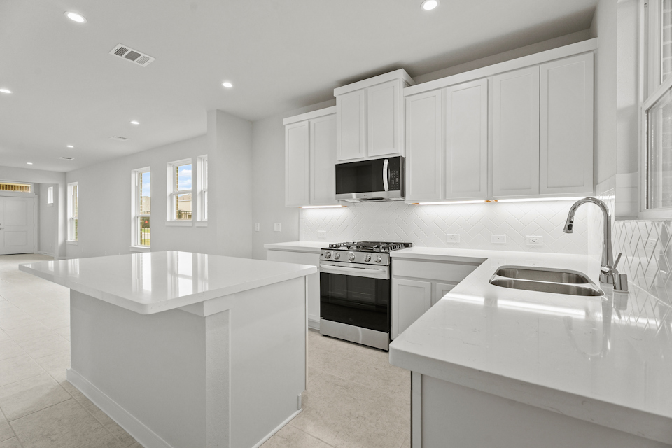 A kitchen with white cabinets.