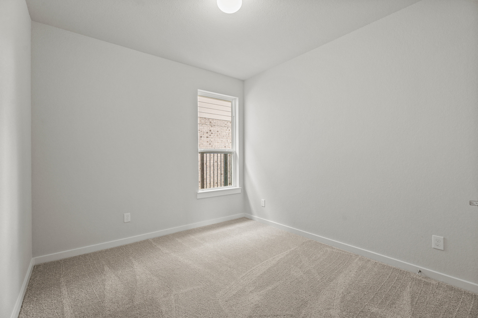 A room with a window and carpet.