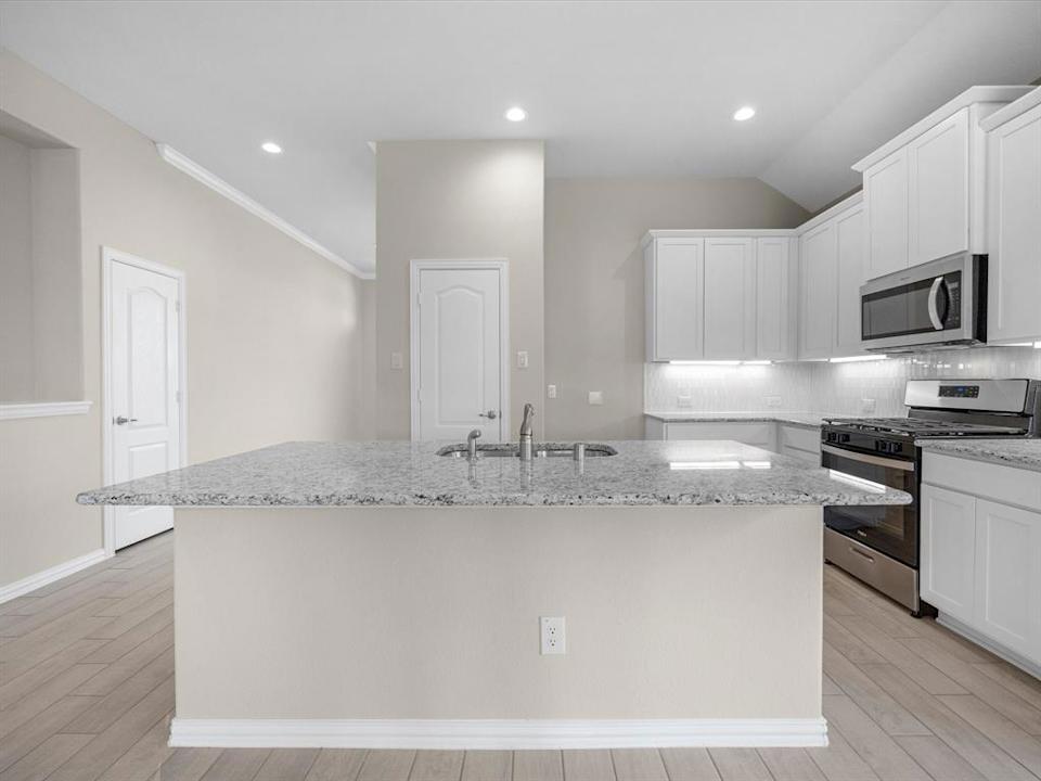 A kitchen with white cabinets.